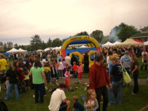 Crowds filling Pierson Park during the Pony Express Days family festival in McKinleyville, 2010, with vendor tents, a bounce house, and families enjoying the day.