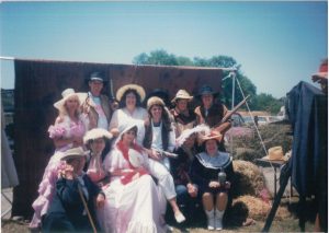Community members dressed in western costumes posing together at the Pony Express Days festival grounds in McKinleyville, 1989.