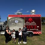 Families Enjoy Frybread Love at Pony Express Days 2026 Festival attendees pose for a photo near the Pierson Park sign and Frybread Love food trailer during Pony Express Days 2026 in McKinleyville.