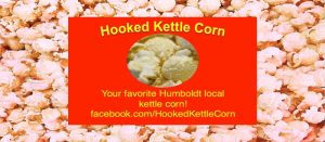 Hooked Kettle Corn logo advertisement featuring a red rectangle with text Your favorite Humboldt local kettle corn and a facebook link over a background of popped kettle corn