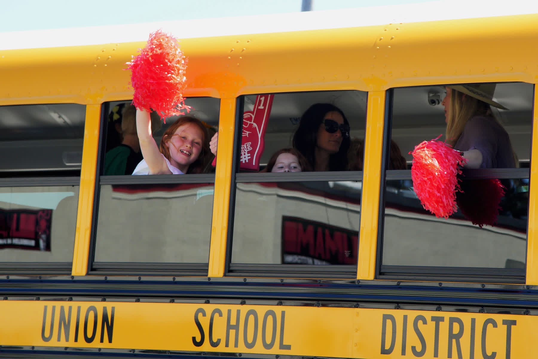 Students Wave from School Bus During Pony Express Days 2026 Parade Students wave pom-poms from a school bus during the Pony Express Days 2026 Parade in McKinleyville, California.