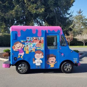 Sweet Treats Ice Cream Truck, a bright blue step van with a pink dripping paint roof design, illustrated cartoon children eating ice cream, and a menu of popsicles on the side
