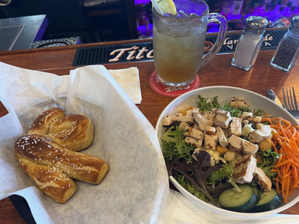 Fresh salad, warm pretzel, and drinks shared over lunch at a McKinleyville restaurant.